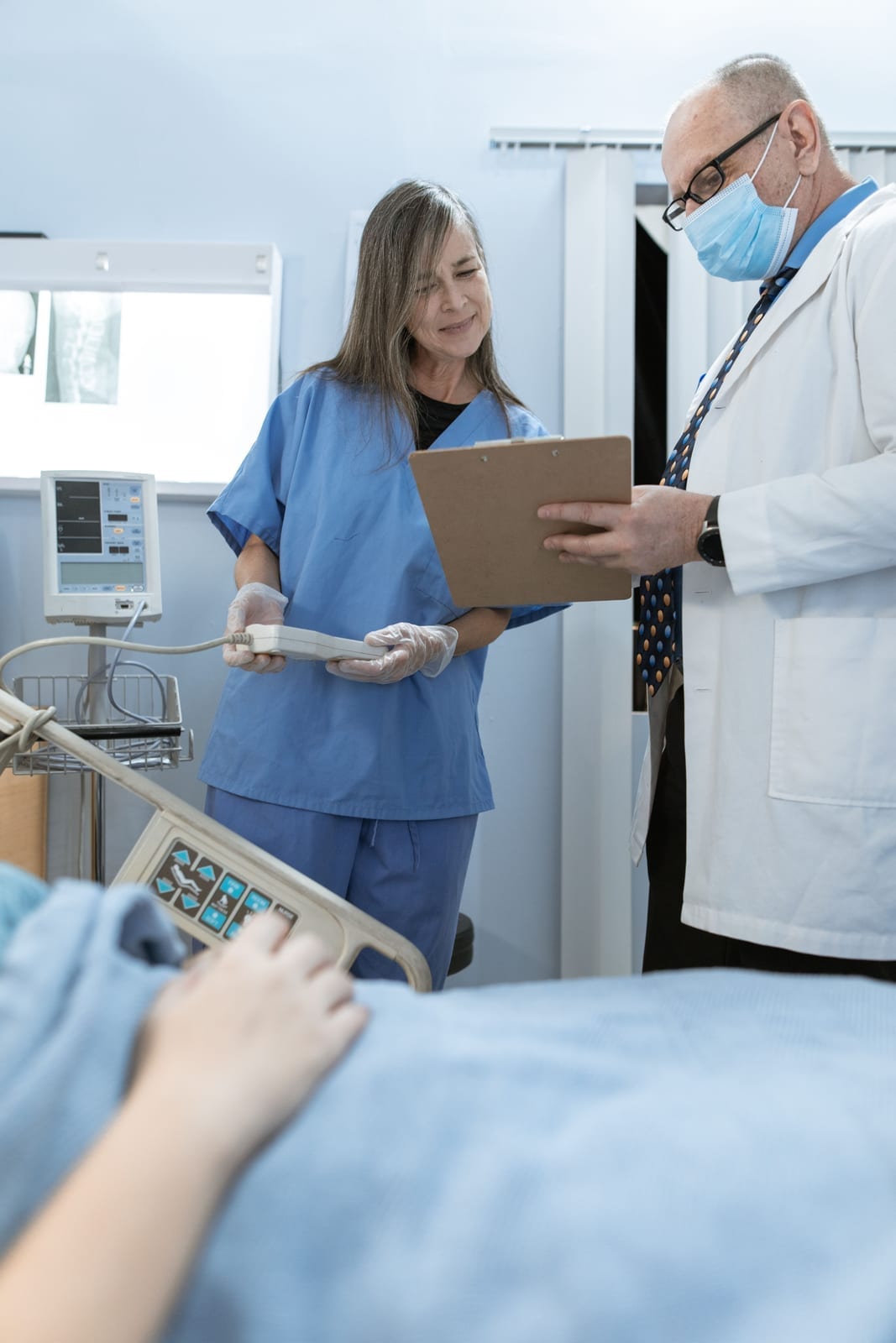 A doctor and a nurse consulting together in a hospital setting
