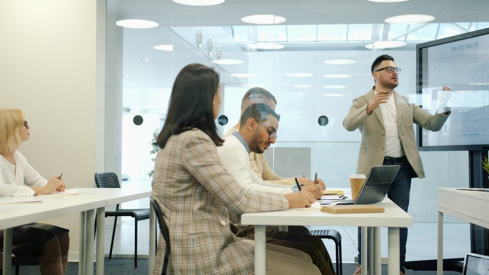 A man presenting to colleagues in a modern office meeting room