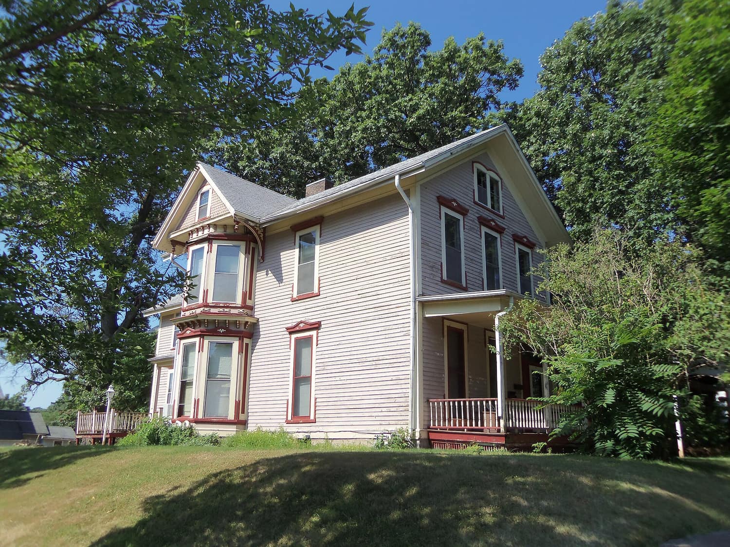 A large wood-frame house with a porch on a residential street in the East 14th Street Historic District of Davenport, Iowa
