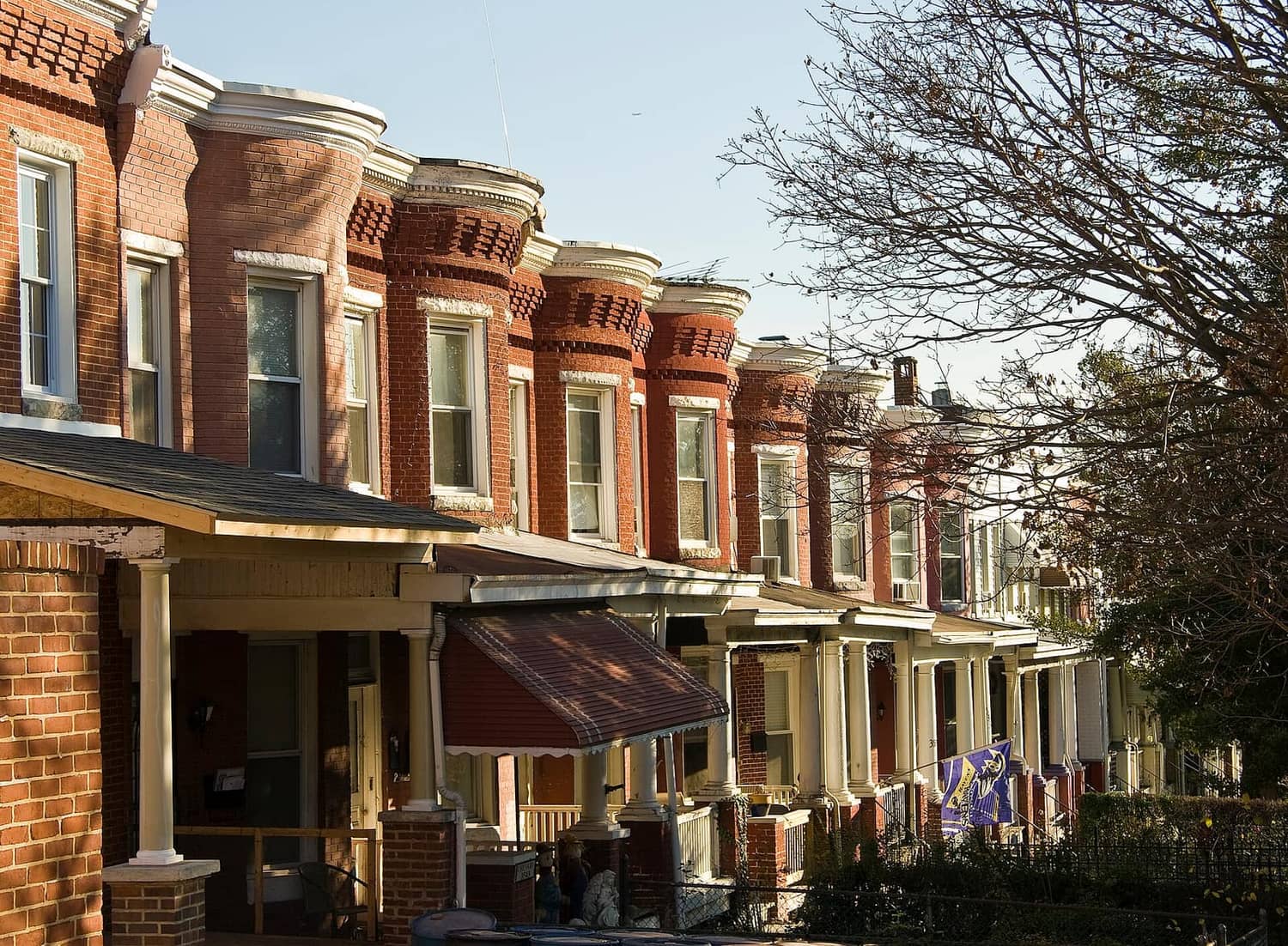 A row of brick and formstone rowhouses along Roland Avenue in the Hampden neighborhood of Baltimore