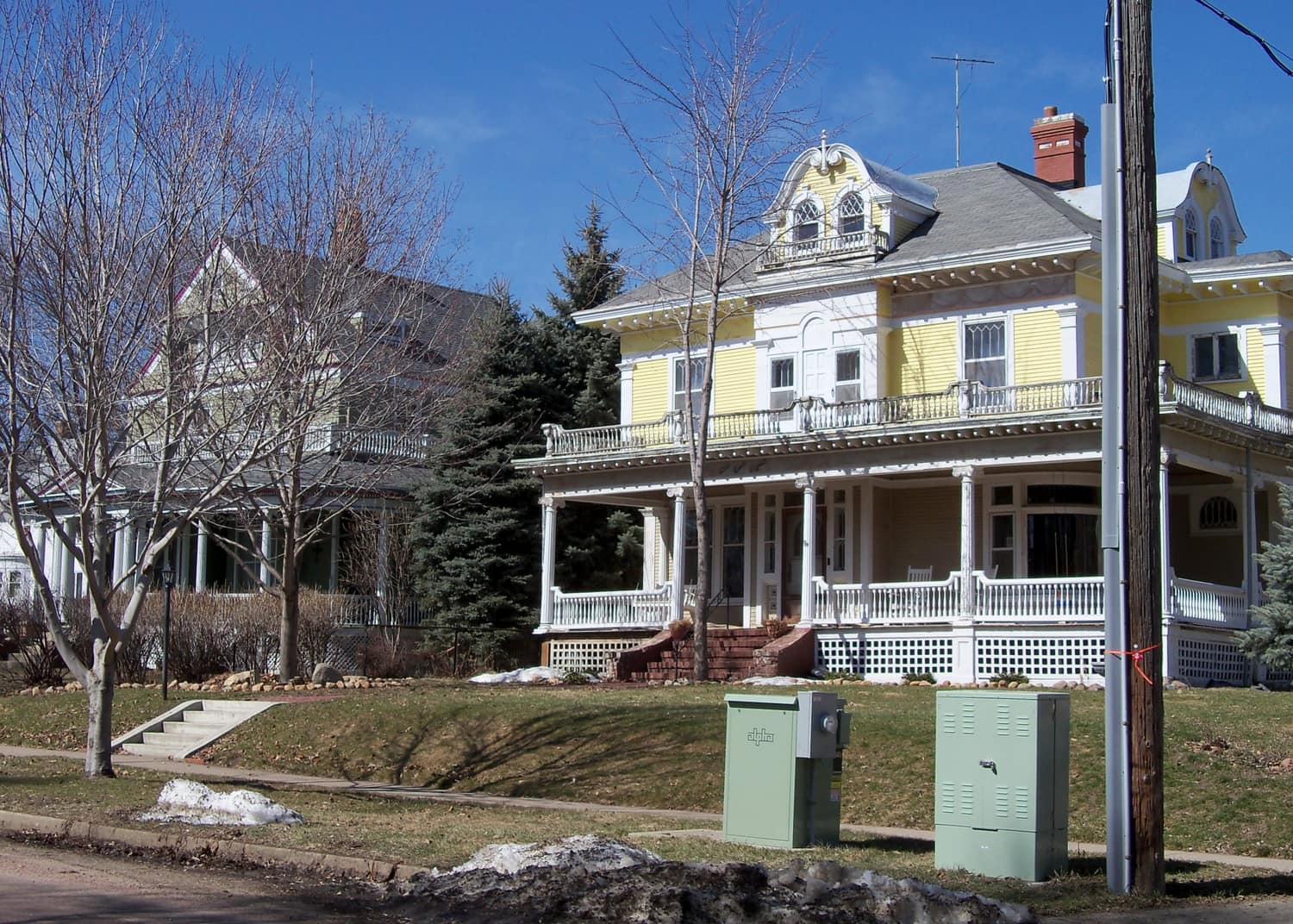 Two-story wood-frame houses with front porches along a shaded street in the Sioux Falls Historic District, South Dakota