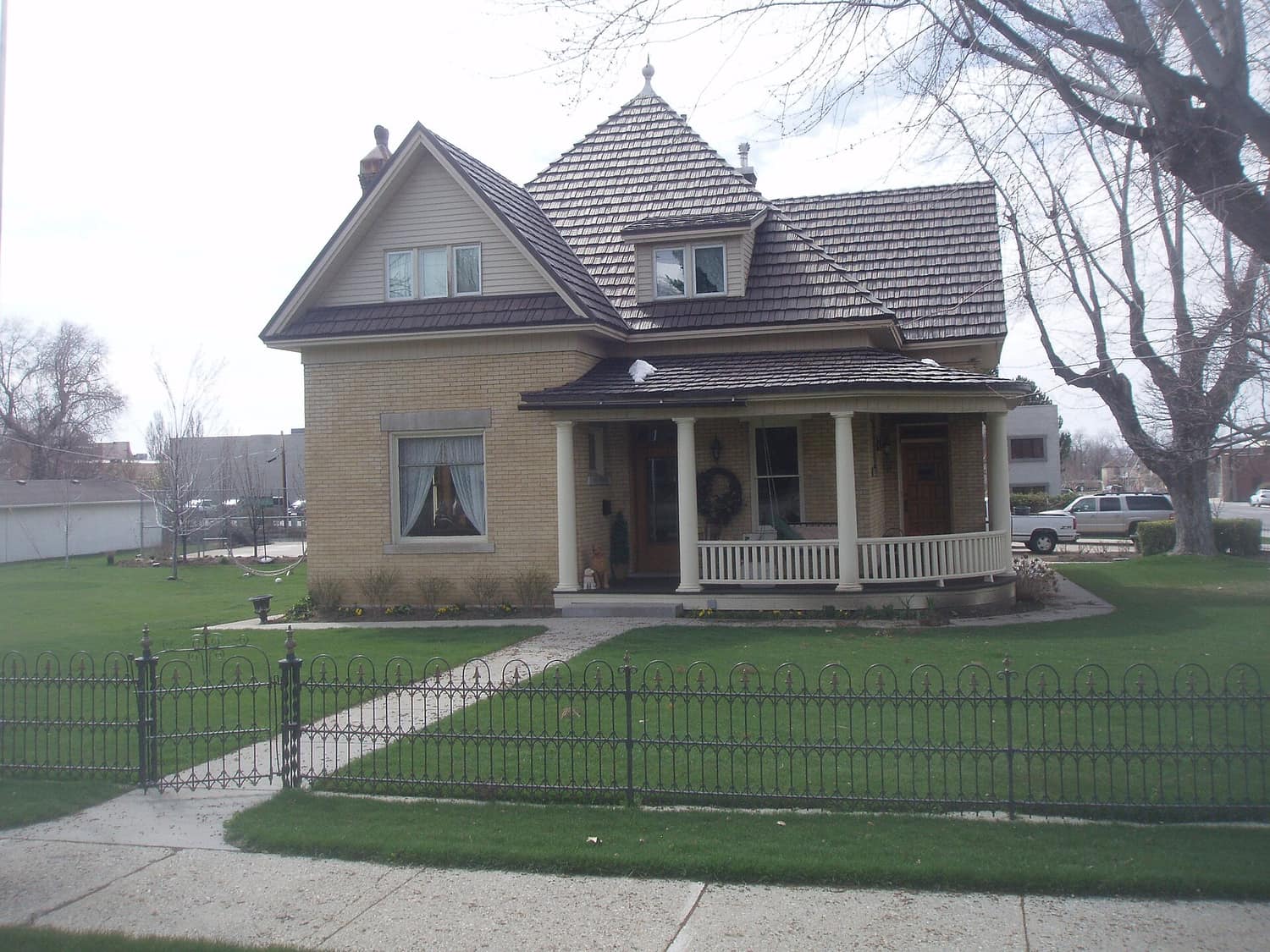 A brick house with a covered porch and mature trees in the Bountiful Historic District, Bountiful, Utah